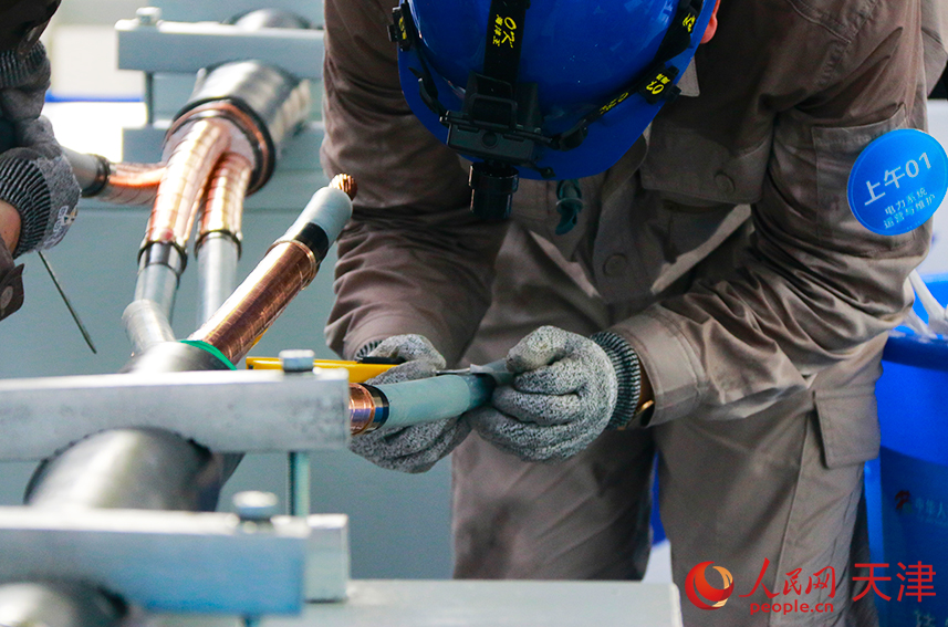 選手們?cè)谂ν瓿芍虚g接頭的制作。人民網(wǎng)記者 唐心怡攝