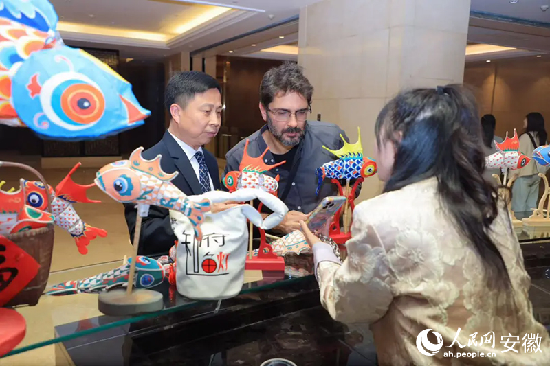 巴西旅行商米內(nèi)維諾·奧爾蒂斯·內(nèi)托·西爾維里奧（中）對魚燈充滿好奇。人民網(wǎng)記者 王曉飛攝